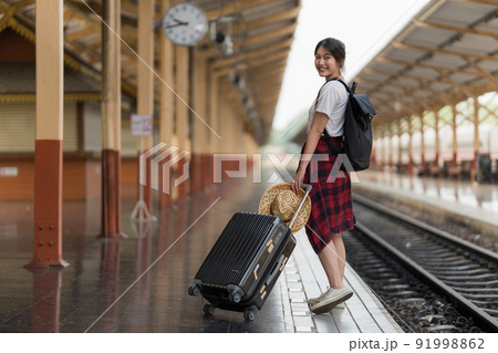 Young traveler woman looking for friend planning trip at train station. Summer and travel lifestyle concept. Young traveler woman looking for friend planning trip at train station. Summer and travel lifestyle concept. 91998862
