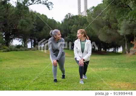 Friendly senior friends exercising in park 91999448