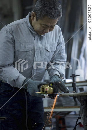 ディスクグラインダー金属をカットとする空調作業服を着た作業員男性 92002329