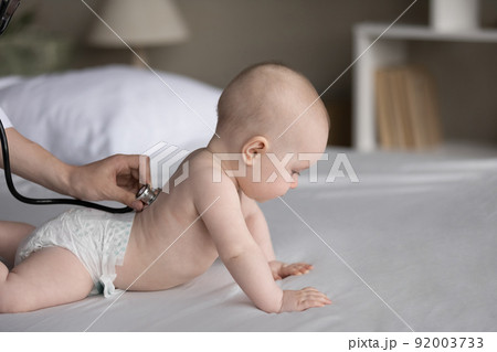 Paediatrician use stethoscope examining health of cute baby in diaper 92003733