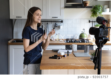 Positive young glamour blogger woman giving video review of mascara 92003757