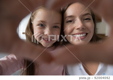 Faces of mom and daughter join fingers showing love symbol Faces of mom and daughter join fingers showing love symbol 92004092