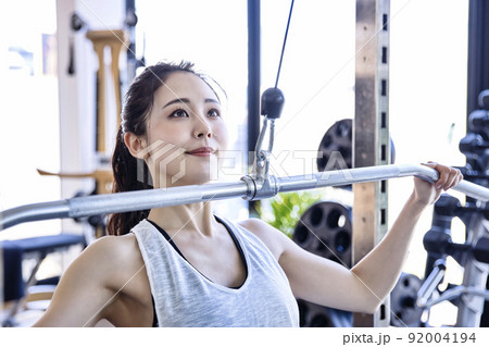 スポーツジムでトレーニングをする若い女性 スポーツジムでトレーニングをする若い女性 92004194