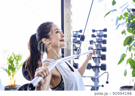 スポーツジムでトレーニングをする若い女性 92004198