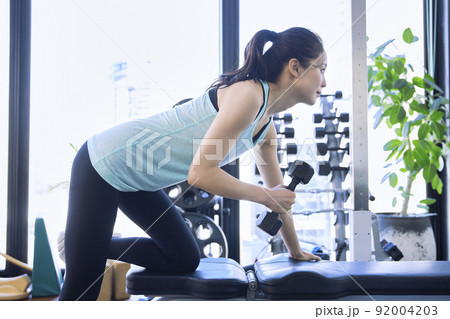 スポーツジムでトレーニングをする若い女性 92004203