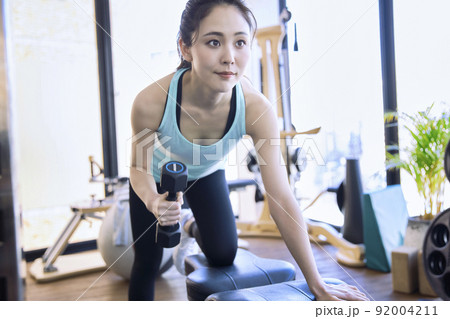 スポーツジムでトレーニングをする若い女性 92004211