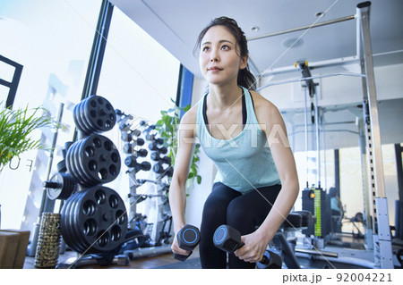 スポーツジムでトレーニングをする若い女性 92004221