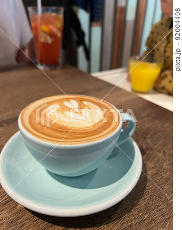 Cup of cappuccino with a pattern on the foam stands on a table 92004408