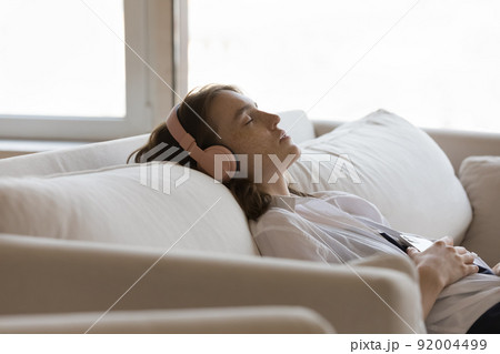 Close up shot relaxed woman in headphones listen music 92004499