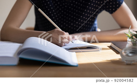 Young student girl preparing for college test, exam, writing notes Young student girl preparing for college test, exam, writing notes 92004582