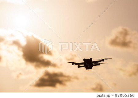 夕日の中を飛行するドローン 92005266