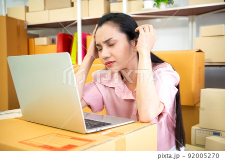 Frustrated and unhappy Asian woman entrepreneur in stressful emotion from economic disaster. Failure and mistake in online business entrepreneur. 92005270