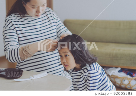 朝ママに髪を結んでもらっている女の子 92005593