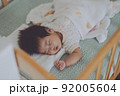 ベビーベッドでよく眠る赤ちゃん 92005604