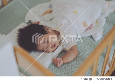 ベビーベッドでよく眠る赤ちゃん 92005604