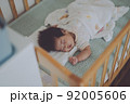 ベビーベッドでよく眠る赤ちゃん 92005606