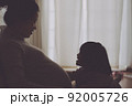 妊婦のママに甘えながらジャレる女の子 92005726