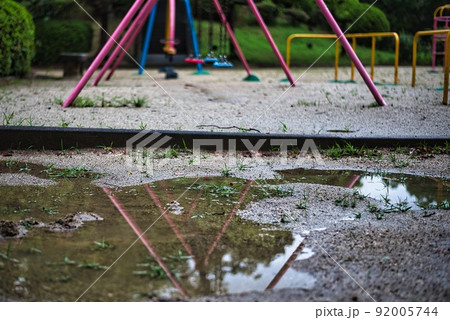 雨上がりの公園の水溜まりに映る遊具 雨上がりの公園の水溜まりに映る遊具 92005744