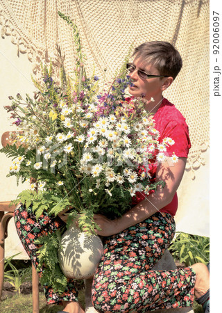 florist at work - portrait of a woman with a bouquet of wild flowers florist at work - portrait of a woman with a bouquet of wild flowers 92006097