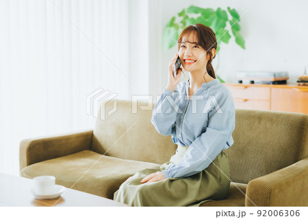 ソファに座って電話をする女性 92006306