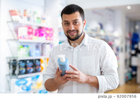 Bearded man choosing cosmetic product at pharmacy 92007956