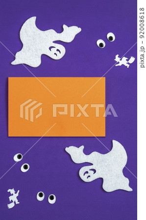 Abstract Halloween composition, background for halloween card, vertical banner. Text Boo,  silhouettes of ghosts and witches on a broomstick. Googly eyes 92008618