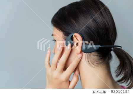 骨伝導イヤホンを使う女性 骨伝導イヤホンを使う女性 92010134