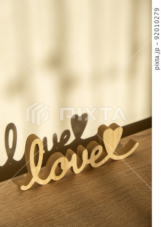 Wooden word love with heart romance. Hard shadows Minimal concept of greeting card for Valentine's Day, Mother's Day, Women's Day Festive banner holiday card concept. Wedding decor. 92010279