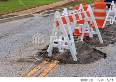 Pothole repair on damaged asphalt, with a carriageway to bypass the area where the repair 92011574