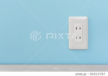 水色の壁に取り付けられた白いコンセント 水色の壁に取り付けられた白いコンセント 92013767