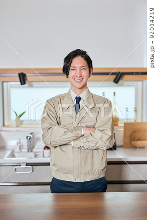 キッチンの前で腕組みをして立つ作業服姿の営業マン キッチンの前で腕組みをして立つ作業服姿の営業マン 92014219