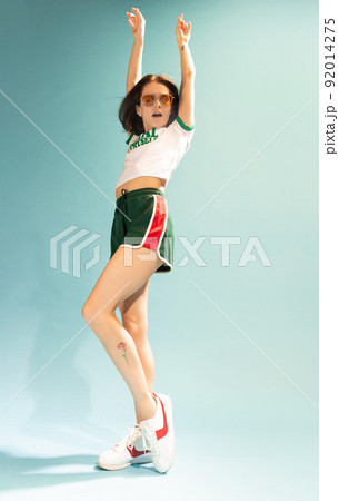 Portrait of cheerful woman in casual summer outfit posing, dancing isolated over light blue background Portrait of cheerful woman in casual summer outfit posing, dancing isolated over light blue background 92014275