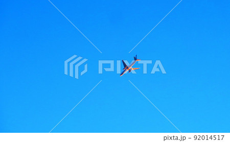 夕暮れの光が射す青空を飛ぶ航空機の風景 夕暮れの光が射す青空を飛ぶ航空機の風景 92014517