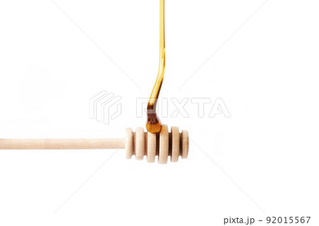 Tasty honey falling on a wooden dipper. Healthy food Tasty honey falling on a wooden dipper. Healthy food 92015567