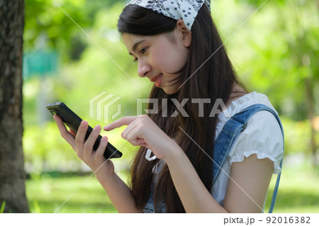 Young Asian teenage relaxing in park 92016382