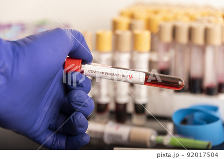 Doctor's hands hold blood samples of the new variant IHU, covid19, coronavirus. Selective approach to the sample tube. 92017504