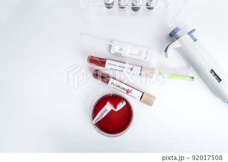 Blood samples of the new variant omicron plus flu FLURONA, covid19, coronavirus. Selective approach to the sample tube. Blood samples of the new variant omicron plus flu FLURONA, covid19, coronavirus. Selective approach to the sample tube. 92017508