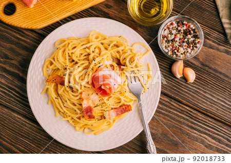 Classic italian pasta carbonara on white plate wooden tabletop, rustic style, Top view copy space 92018733