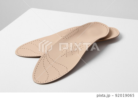 Insoles isolated on a white background. Medical orthopedic insoles. Foot care. Insole cutaway layers. Treatment and prevention of flat feet and foot diseases. Inner soles of shoes. 92019065