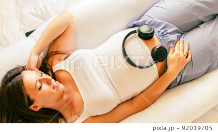 Pregnant music woman listen. Mother belly listen headphones sound. Pregnancy woman listening to music. Concept maternity, pregnancy, childbirth. Pregnant music woman listen. Mother belly listen headphones sound. Pregnancy woman listening to music. Concept maternity, pregnancy, childbirth. 92019705