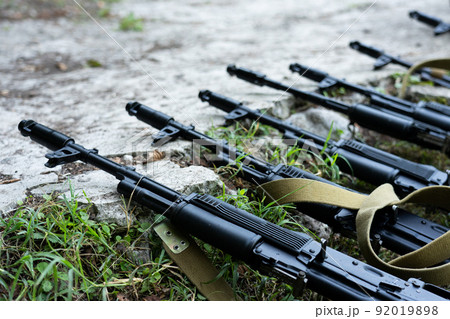 Kalashnikov assault rifles lying on the ground. 92019898