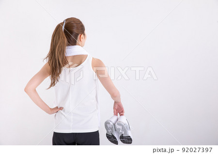 タオルを肩に掛けてスニーカーを持つ女性　sports	 92027397
