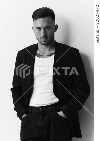 Modelling snapshots. Evil self-confident attractive handsome man in classic suit hold hand on pocket posing isolated in white studio background. Black and White concept. Fashion offer. Copy space Modelling snapshots. Evil self-confident attractive handsome man in classic suit hold hand on pocket posing isolated in white studio background. Black and White concept. Fashion offer. Copy space 92027472
