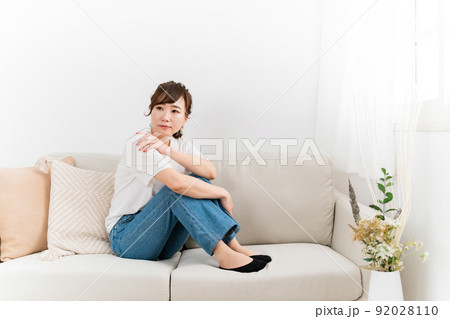 家のソファで落ち込む日本人女性(考える) 家のソファで落ち込む日本人女性(考える) 92028110