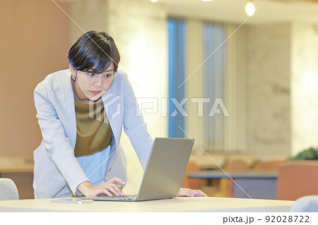 立ったまま真剣にPCを見るビジネスウーマン1 92028722