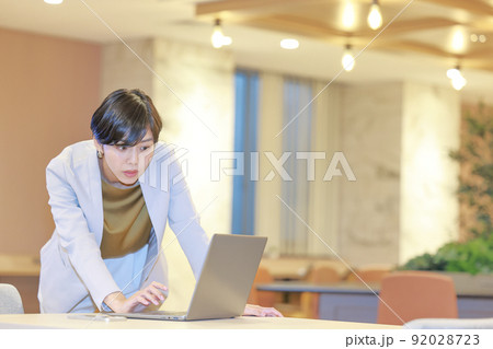 立ったままPCを見て気になる点を見付けるビジネスウーマン1 92028723