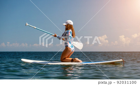 Woman sup sea. Happy healthy fit woman in bikini relaxing on a sup surfboard, floating on the clear turquoise sea water. Recreational Sports. Stand Up Paddle boarding. Summer fun, holidays travel. Woman sup sea. Happy healthy fit woman in bikini relaxing on a sup surfboard, floating on the clear turquoise sea water. Recreational Sports. Stand Up Paddle boarding. Summer fun, holidays travel. 92031100