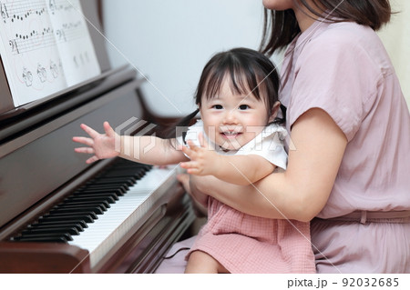 アップライトピアノを弾く1歳の女の子とママ 92032685