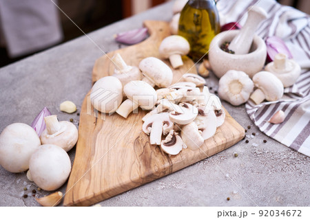 champignon mushrooms on wooden cutting board at domestic kitchen 92034672