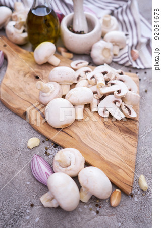 champignon mushrooms on wooden cutting board at domestic kitchen 92034673